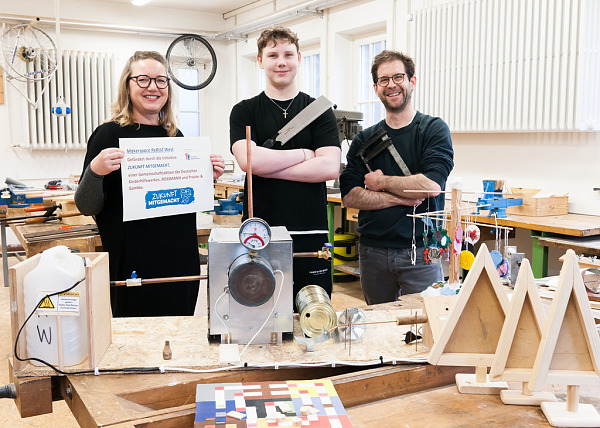 Drei Personen in einer alten Holzwerkstatt, die zum Maker Space für Schülerinnen und Schüler umfunktioniert wurde