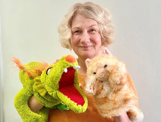 Sabine Kurz, Leiterin des Landesprogramms Startchancen, zeigt zwei Handpuppen