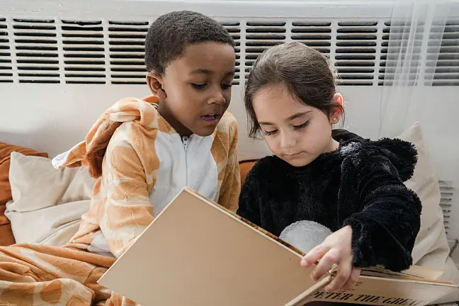 Zwei Kinder, die sich ein Buch anschauen